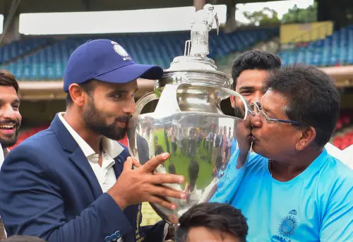 Madhya Pradesh's captain Aditya Shrivastava and head coach Chandrakant Pandit kiss the Ranji Trophy | PTI