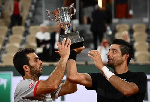 Marcelo Arevalo (R) and Netherlands' Jean-julien Rojer (L) celebrate with their trophy | AFP