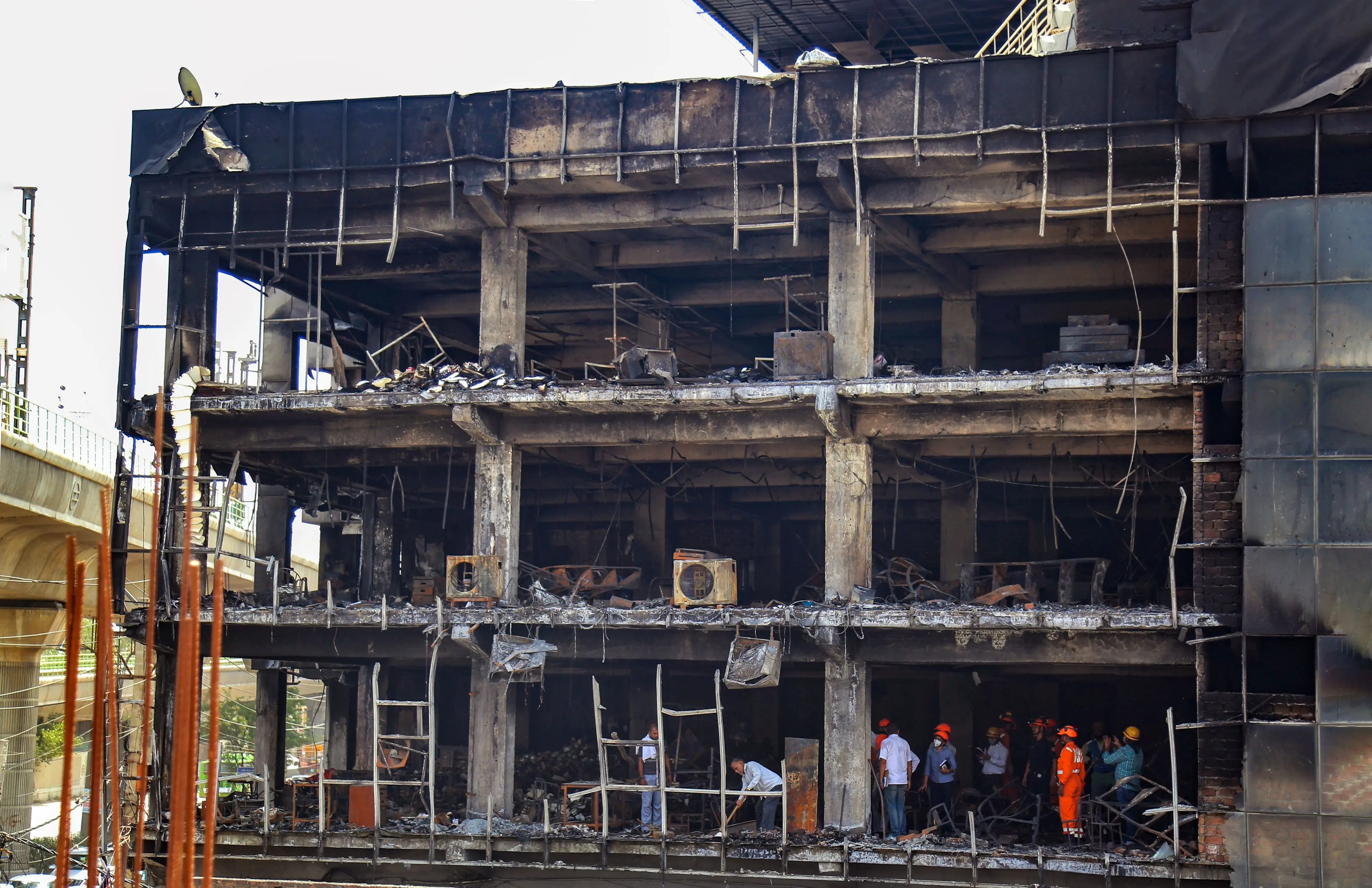 Officials investigate the Mundka fire, in New Delhi on Sunday. Twenty-seven people have died so far in the Mundka fire. Photo: PTI