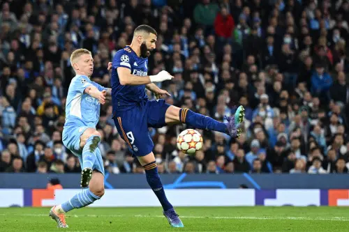 Karim Benzema is tackled by Manchester City's Ukrainian midfielder Oleksandr Zinchenko (L) | AFP