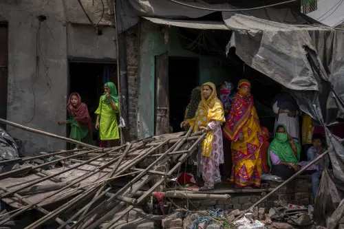 Residents stand amidst the rubble of demolished illegal structures at a residential area of Jahangirpuri in New Delhi on April 20, 2022, during an anti-encroachment drive following clashes between members of two communities on April 16 during a 'Hanuman Jayanti' religious procession | Photo: AFP
