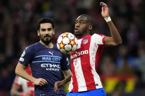 Ilkay Gundogan, left, watches as Atletico Madrid's Geoffrey Kondogbia controls the ball | AP