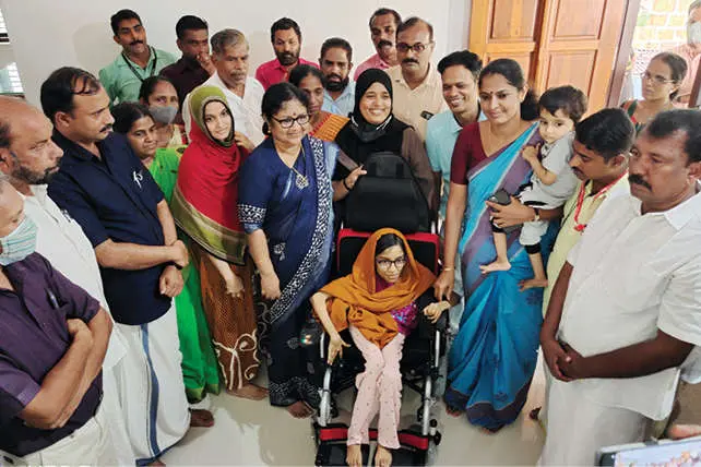 Minister R Bindhu gifts electric wheelchair to Kannur girl battling with SMA