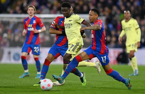 Jordan Ayew (2L) and Nathaniel Clyne (2R) vie for the ball with Bukayo Saka (C) | AFP