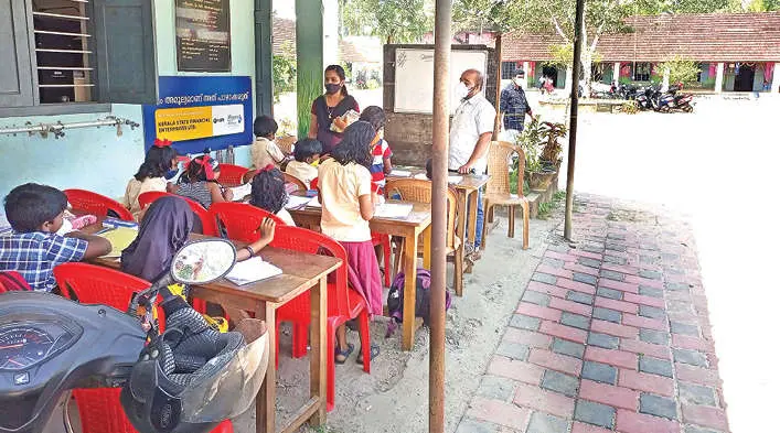 Classes being held at Government LP school in Kalavoor with students seated in cycle shed | Photo: Mathrubhumi