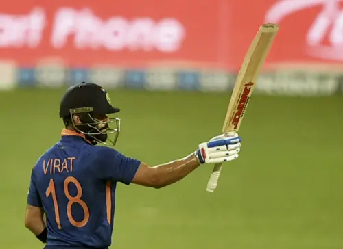 Virat Kohli raises his bat after scoring fifty runs I PTI