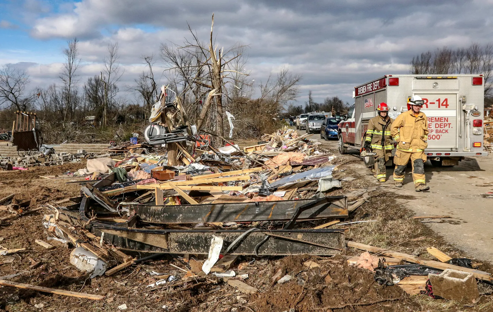 Firefighters walk along debris scattered along Kentucky after tornado | Photo: AP