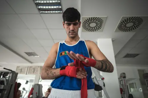 An Afghan boxer wraps his hands as he trains in a gym  | AFP
