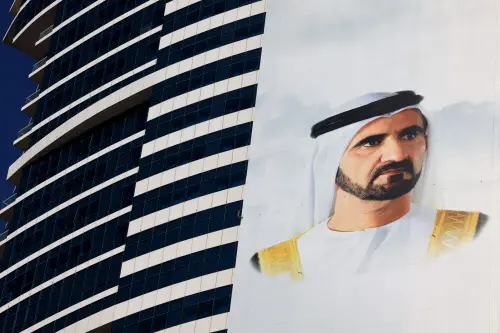 A banner bearing the portraits of Emirati President Khalifa bin Zayed Al-Nahyan (unseen) and Dubai's ruler Mohammed bin Rashid Al-Maktoum hangs on the side of a building in the Gulf emirate, for the United Arab Emirates' 50th anniversary. | Photo: AFP