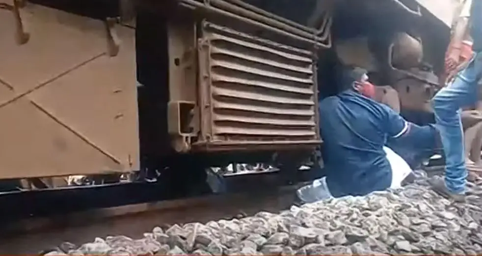 People trying to pull the man from under the train | Screengrab: Mathrubhumi News