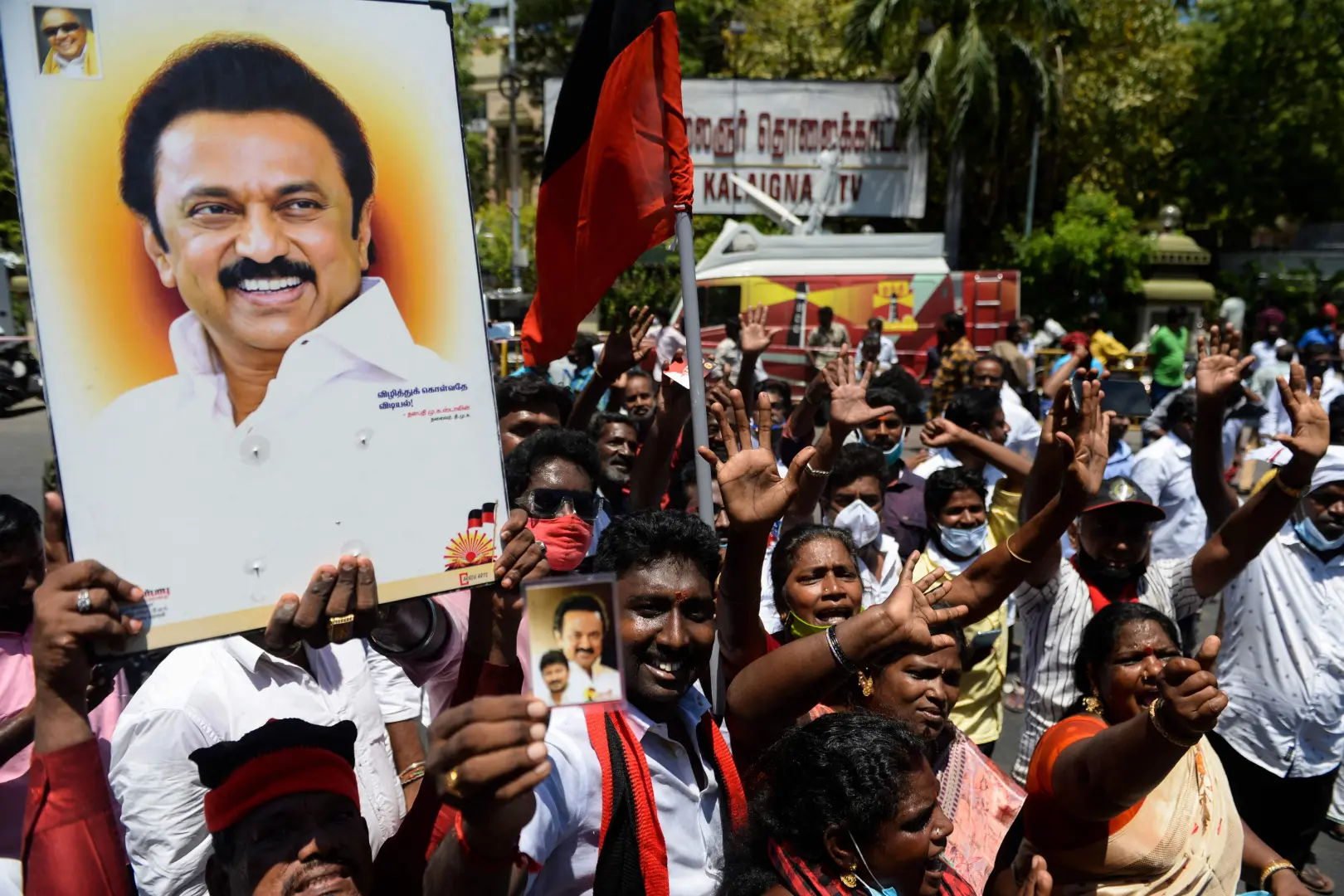 Members of the DMK party carry placards with the image of DMK leader MK Stalin while celebrating election victory | Photo: AFP