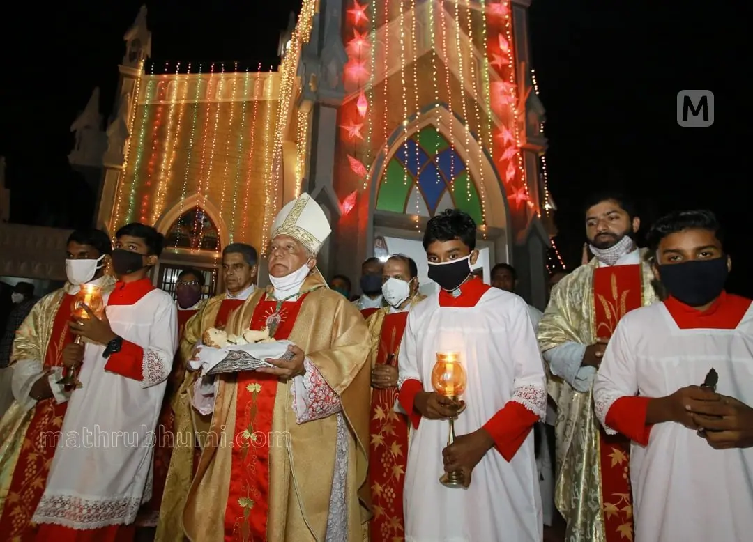 Bishop Dr Alex Vadakkumthala carrying Infant Jesus to the crib amid midnight mass at Holy Trinity Cathedral in Burnassery in Kannur | Photo: Latheesh Poovathur | Mathrubhumi