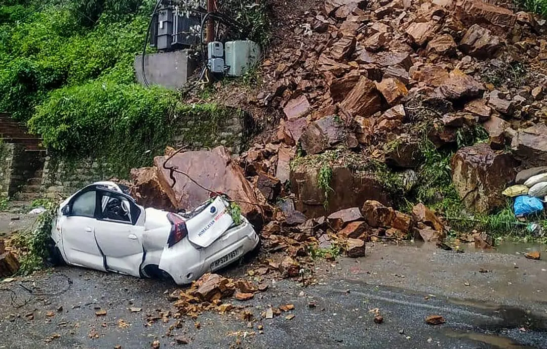 Shimla: A car buried under the debris after a landslide due to heavy rainfall, at Vikasnagar in Shimla on Wednesday.