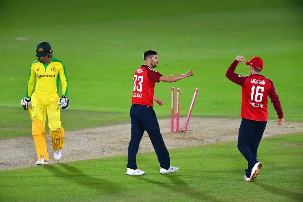 England's Mark Wood, center, celebrates with captain Eoin Morgan, right, the dismissal of Australia's Alex Carey (AP photo)