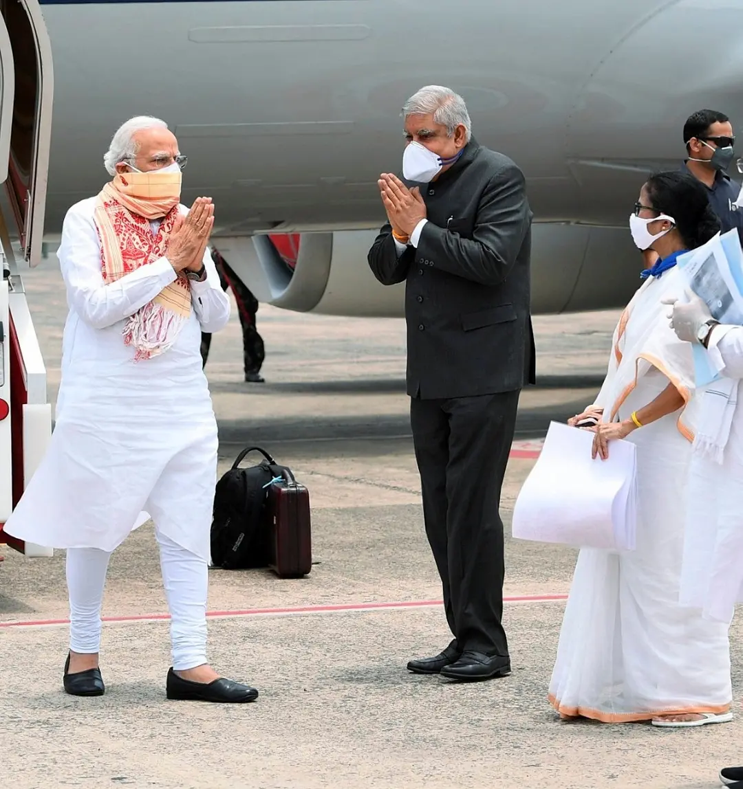 Prime Minister Narendra Modi being received by West Bengal Governor Jagdeep Dhankar and Chief Minister Mamata Banerjee on his arrival at the airport to take stock of the situation in the state after Cyclone Amphan, in Kolkata, Friday. (PTI Photo) (