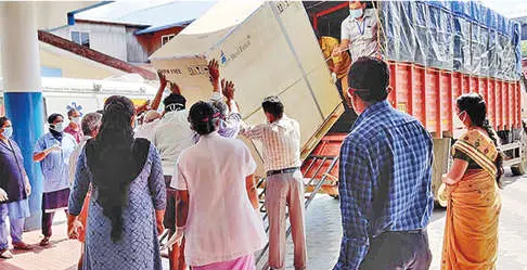 Doctors and other staff of Thuravoor hospital unload COVID testing equipment from lorry