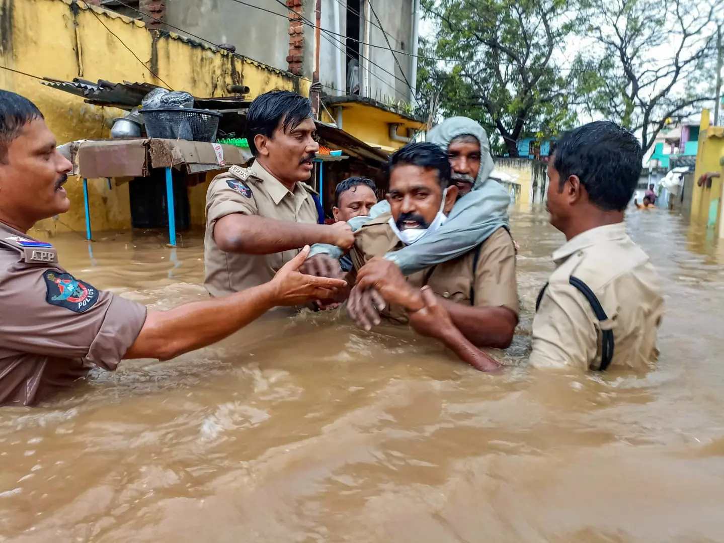 A policeman carries an old man on his back to evacuate him from a flooded area at Rajampet in Kadapa district | Photo: PTI