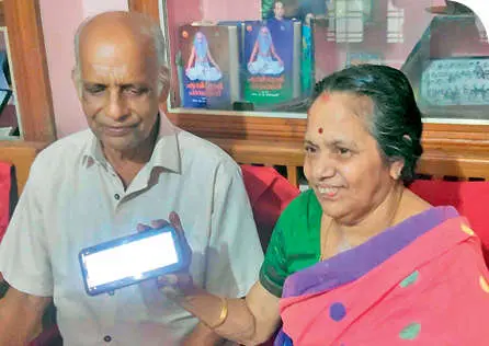 Kamala Bhai shows her MA marklist on a mobile phone. He husband Janardhanan Pillai is also seen. Photo: Mathrubhumi