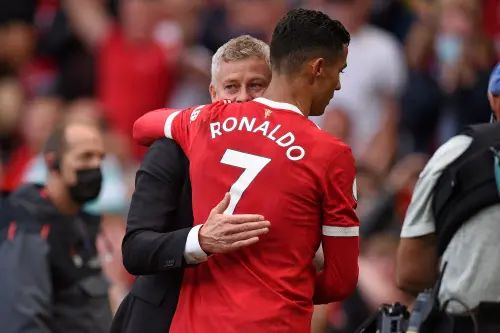 Ole Gunnar Solskjaer (L) embraces Cristiano Ronaldo (R) | AFP