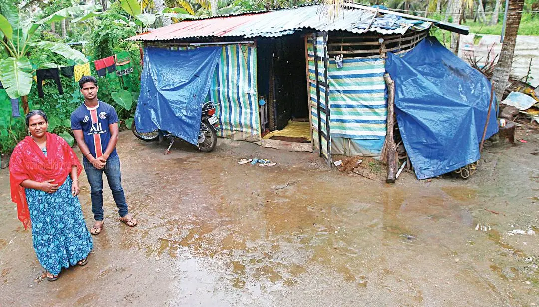 Chithra and her son near their plastic shed