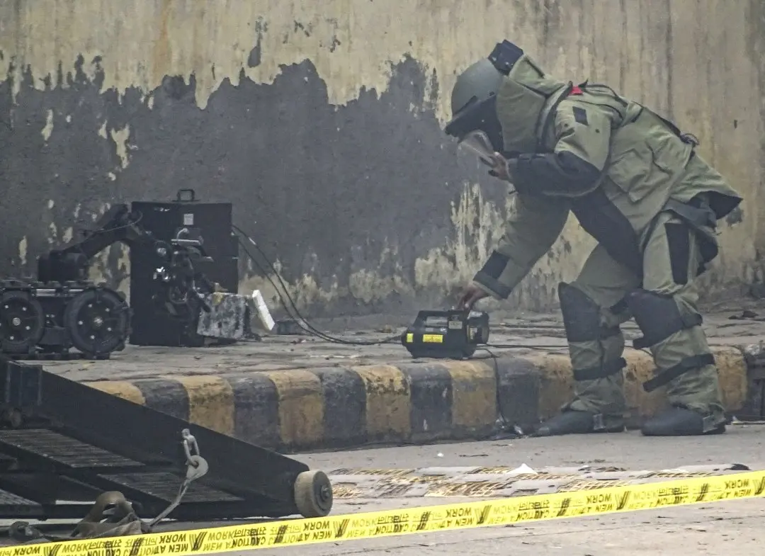 A member of a Bomb Disposal Squad attempts to defuse an IED bomb found inside a bag at Ghazipur flower market in New Delhi. Photo: PTI