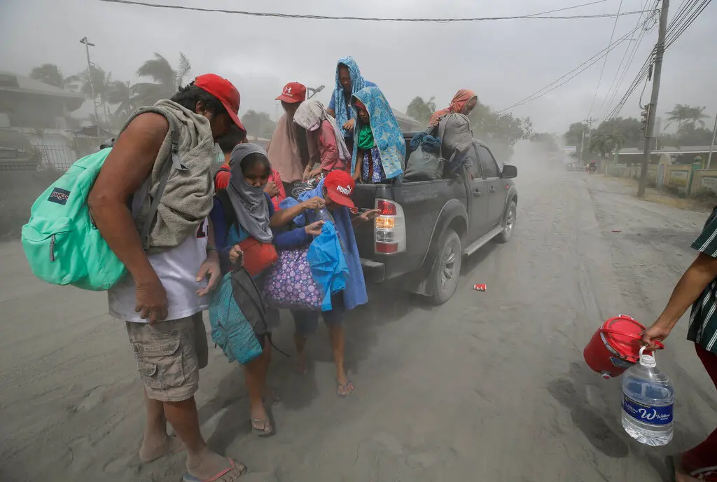A family evacuates to safer grounds as Taal volcano in Tagaytay, Cavite province, southern Philippines on Monday. (AP Photo)