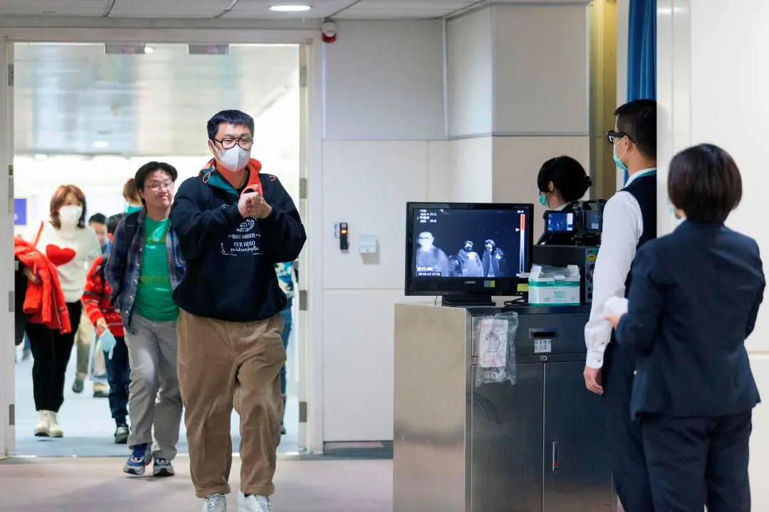Taiwan's Center for Disease Control personnel using thermal scanners screen passengers at the Taoyuan International Airport. Photo:AFP