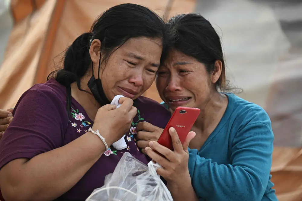 Women react after hearing of the death of a relative at the site of an under-construction building collapse in Bangkok | AFP