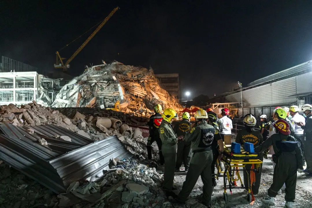 Rescue teams arrive with a stretcher to evacuate the injured at a construction site where a building collapsed in Bangkok following an earthquake | Photo: AFP