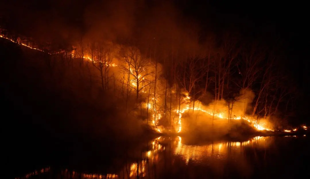 Smoke rises from burning trees as a wildfire is reflected in the waters of the Nakdong River in Andong (Photo: AFP)
