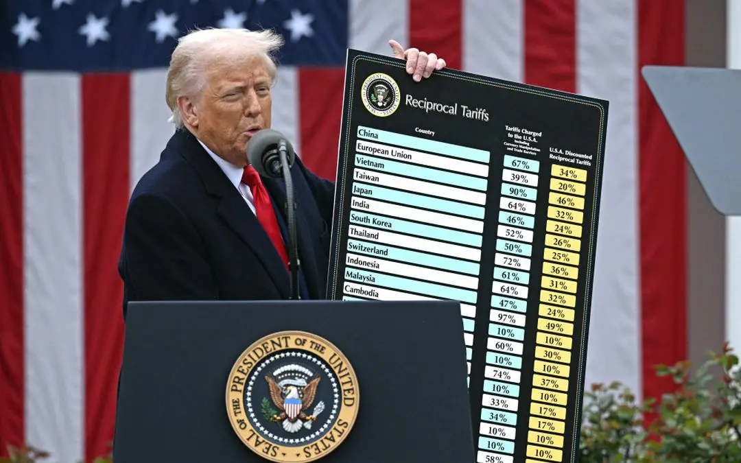 US President Donald Trump delivers remarks on reciprocal tariffs as US Secretary of Commerce Howard Lutnick holds a chart during an event in the Rose Garden entitled 'Make America Wealthy Again' at the White House in Washington, DC
