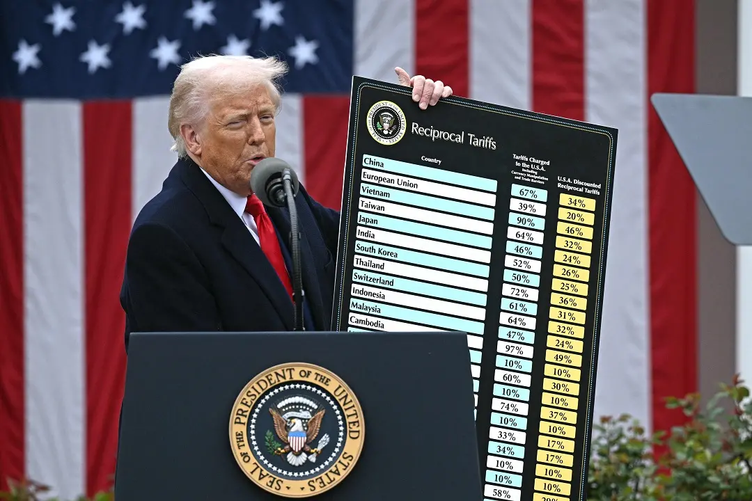 US President Donald Trump delivers remarks on reciprocal tariffs as US Secretary of Commerce Howard Lutnick holds a chart during an event in the Rose Garden entitled 'Make America Wealthy Again' at the White House in Washington, DC | Photo: AFP