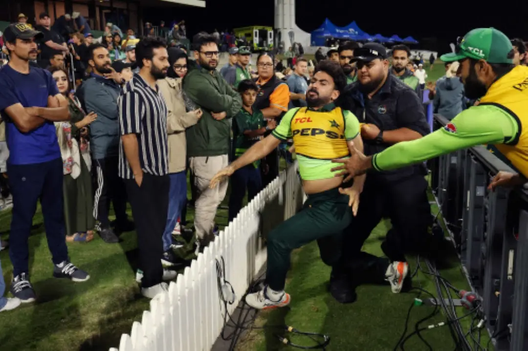 Pakistan's Khushdil Shah (C) is held back after reacting to comments from the crowd during the third one day international (ODI) cricket match between New Zealand and Pakistan at Bay Oval in Mount Maunganui. | Photo: AFP