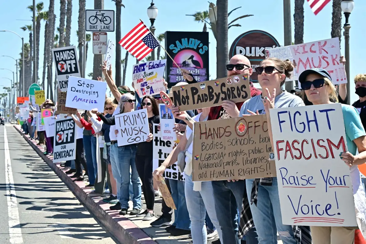 Protestors gather during a 'Hands Off!' protest against the policies of US President Donald Trump and his advisor, Tesla CEO Elon Musk, in Huntington Beach, California | Photo: AFP