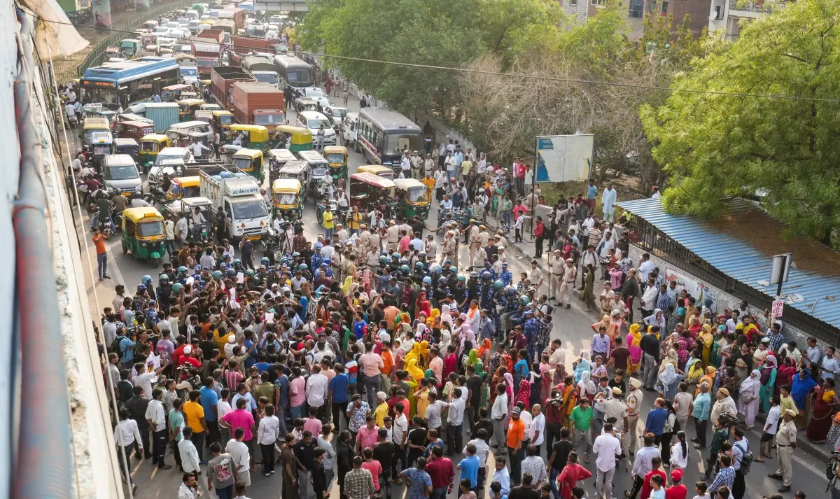 People block a road during a protest after a 17-year-old boy was stabbed to death, in Delhi's Seelampur area | Photo: PTI