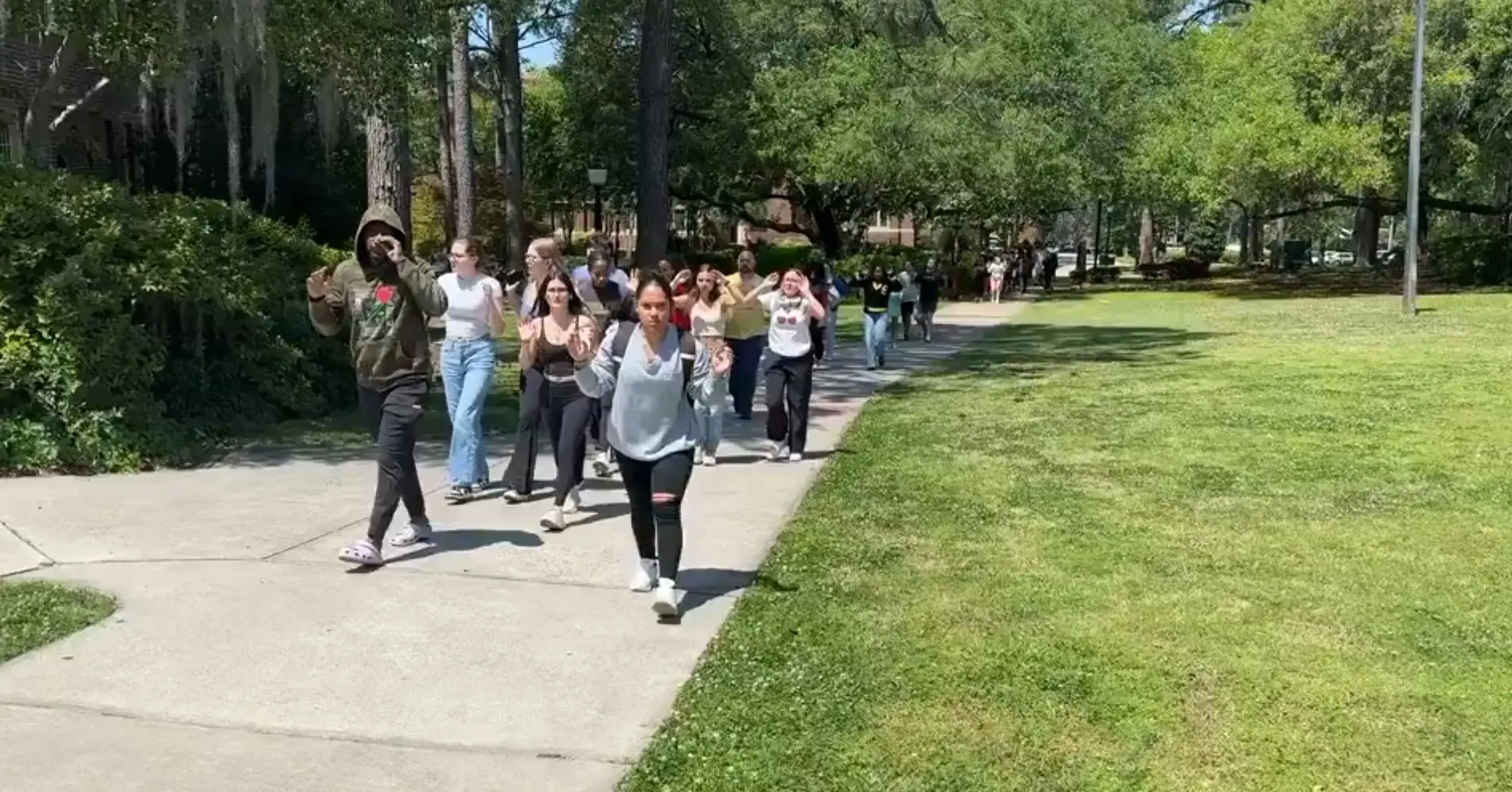 Florida State students evacuate from an area near the shooting scene with their hands above their head | Photo: X/ MyLordBebo