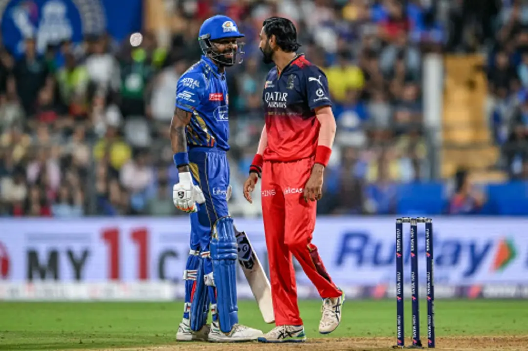 Mumbai Indians' captain Hardik Pandya (L) speaks with his brother and Royal Challengers Bengaluru's player Krunal Pandya during the Indian Premier League (IPL) Twenty20 cricket match between Mumbai Indians and Royal Challengers Bengaluru at the Wankhede Stadium in Mumbai. | Photo: AFP