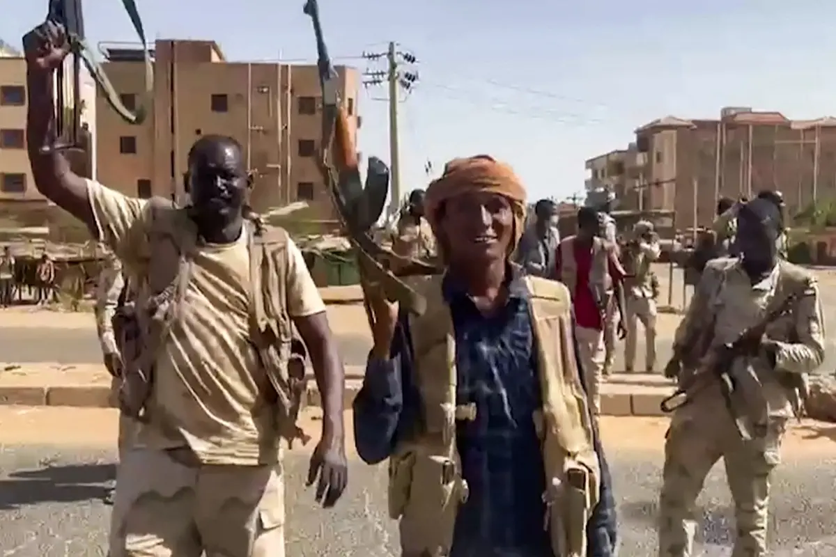 Sudanese paramilitary Rapid Support Forces (RSF) fighters wave assault rifles as they cross a street in the East Nile district of greater Khartoum | File photo: AFP