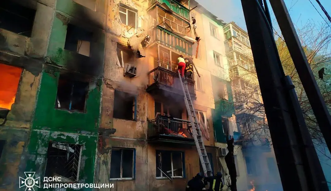 Ukrainian rescuers evacuate a woman from a burning residential building following a drone attack (Photo: AP)