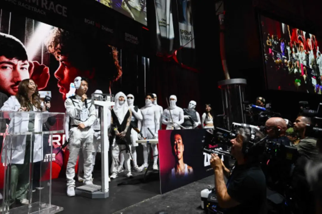 YouTuber Jimmy Zhang (R) stands on stage with a sperm costumed entourage during the undercard weigh-in during a Sperm Racing competition in Los Angeles, California. | Photo: AFP
