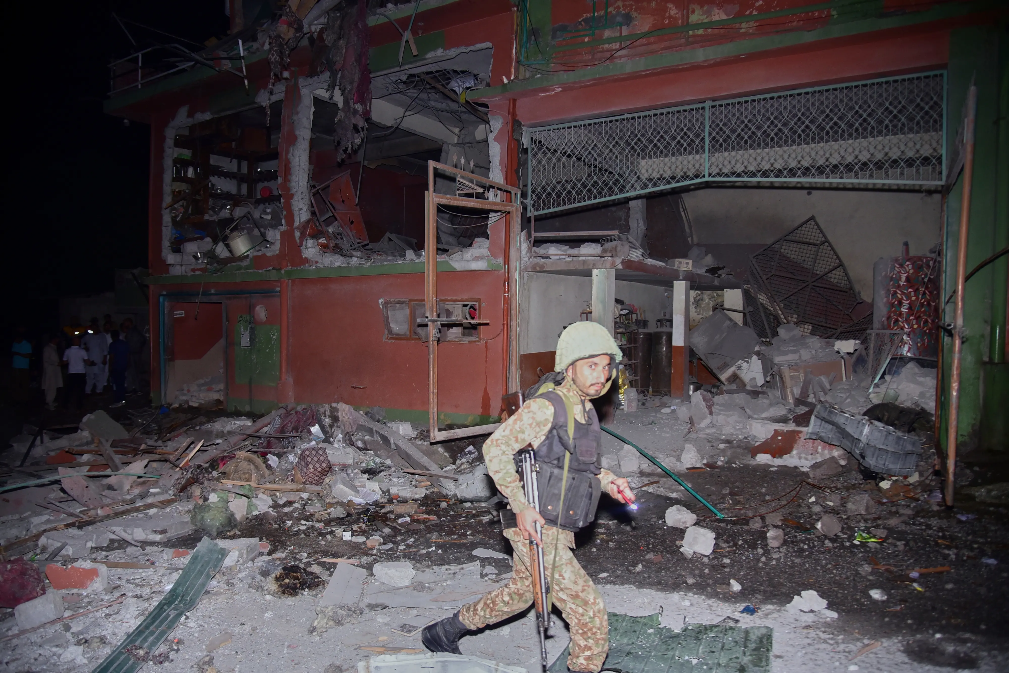 An army soldier examines a building damaged by a suspected Indian missile attack near Muzaffarabad on May 7, 2025. (AP Photo/M.D. Mughal)