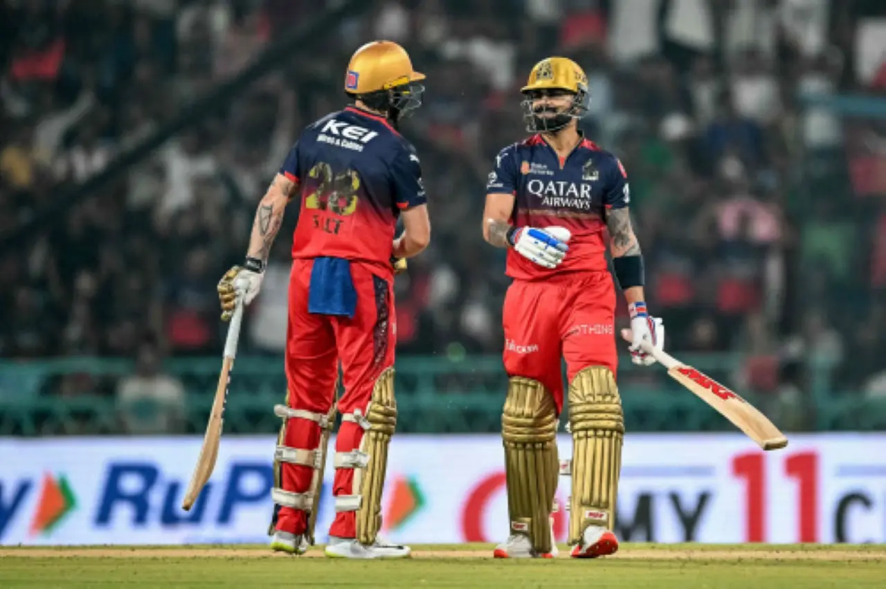 Royal Challengers Bengaluru's Virat Kohli (R) speaks with his teammate Phil Salt during the Indian Premier League (IPL) Twenty20 cricket match between Royal Challengers Bengaluru and Sunrisers Hyderabad at the Ekana Cricket Stadium in Lucknow. | Photo: AFP