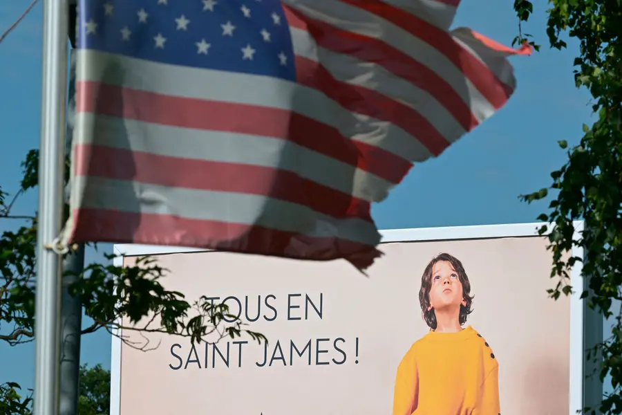 An advertising poster is seen behind a US flag
