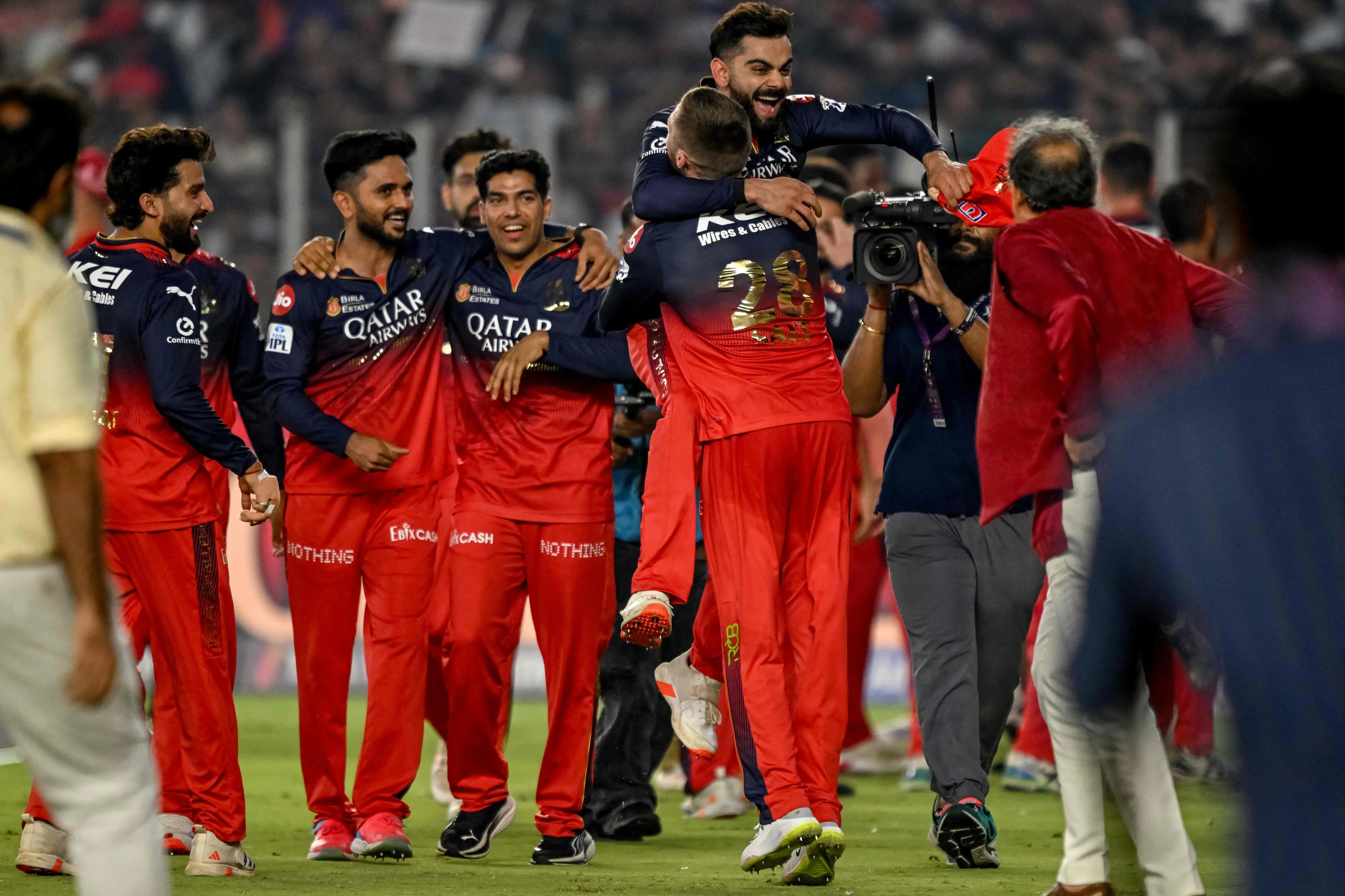 Royal Challengers Bengaluru's players celebrate with Virat Kohli (top) after winning the IPL final match between Royal Challengers Bengaluru and Punjab Kings at the Narendra Modi Stadium in Ahmedabad | Photo: AFP