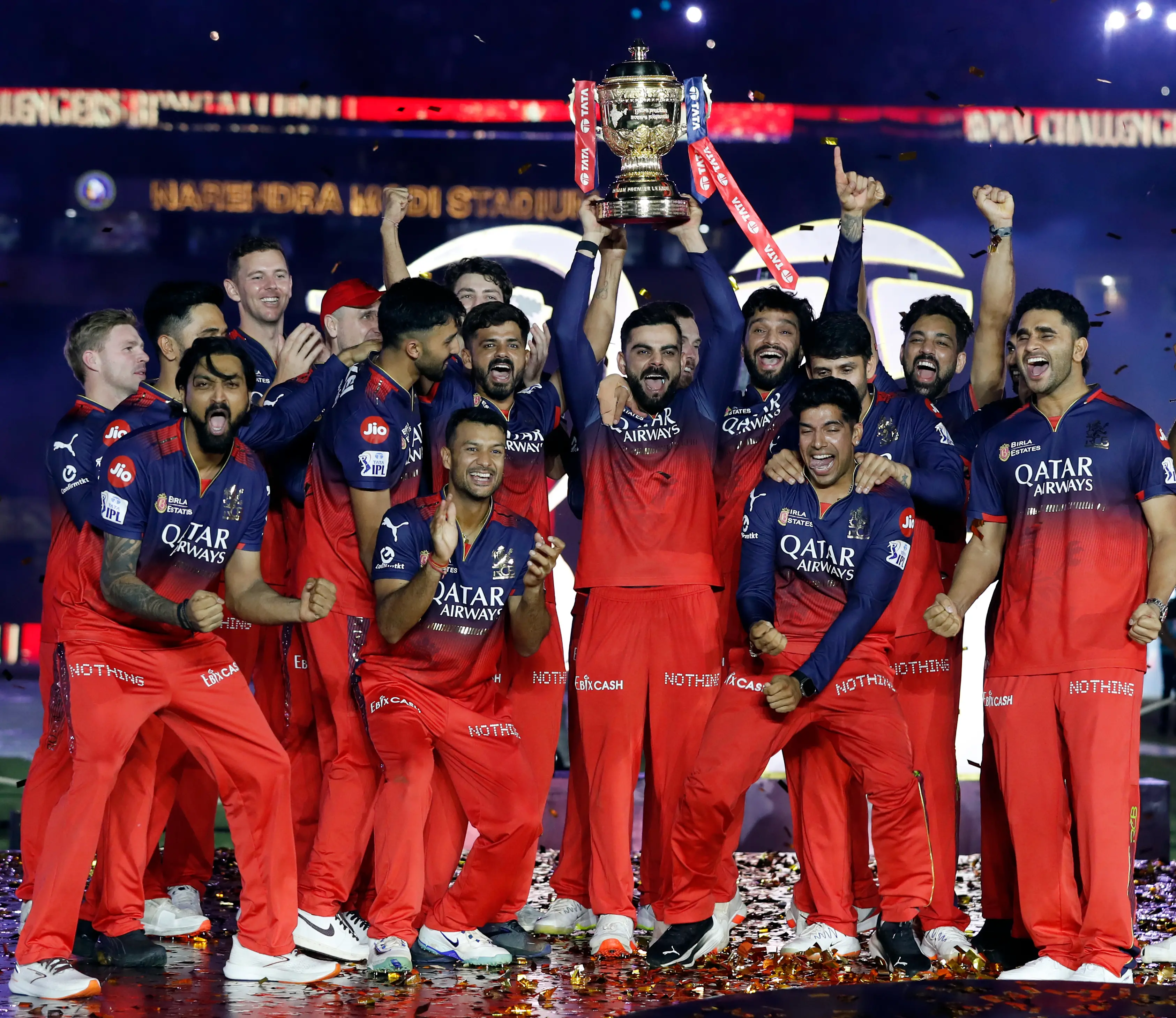 Royal Challengers Bengaluru's players celebrate with the trophy after winning the Indian Premier League 2025 final match against Punjab Kings, at Narendra Modi Stadium in Ahmedabad. | Photo: ANI