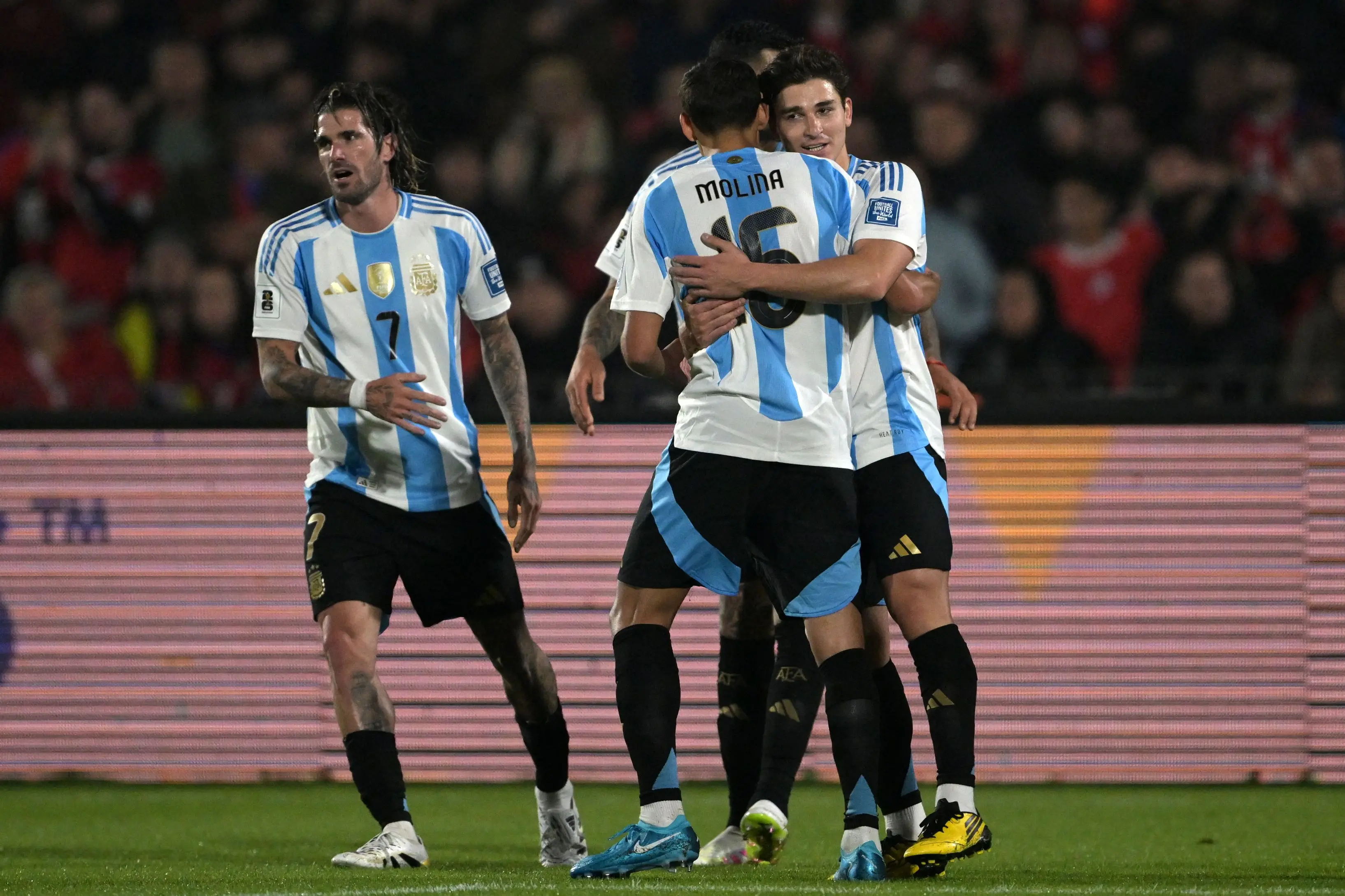 Julian Alvarez (R) celebrates with teammate Nahuel Molina and Rodrigo De Paul after scoring | AFP