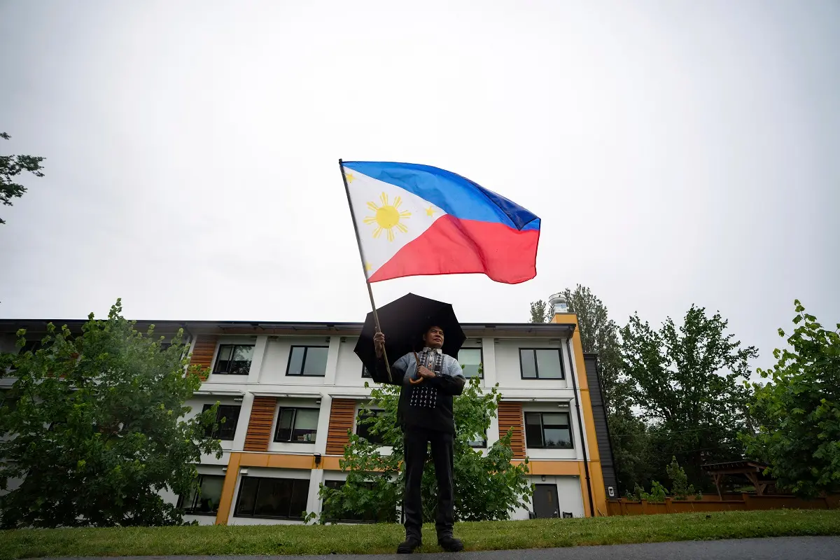 A man waves the Philippine national flag | Photo: AP