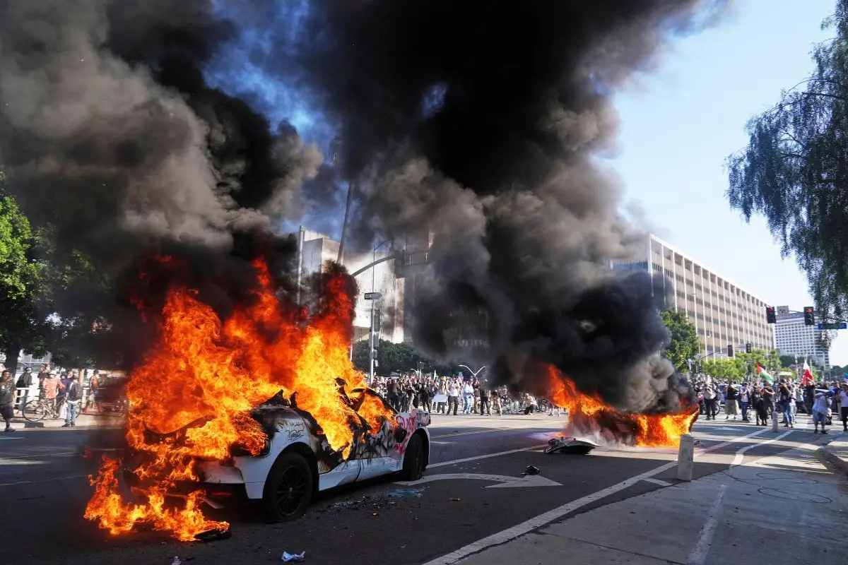 Two Waymo taxis burn near the metropolitan detention center of downtown Los Angeles on June 8, 2025, following  immigration raid protest (Photo: AP)