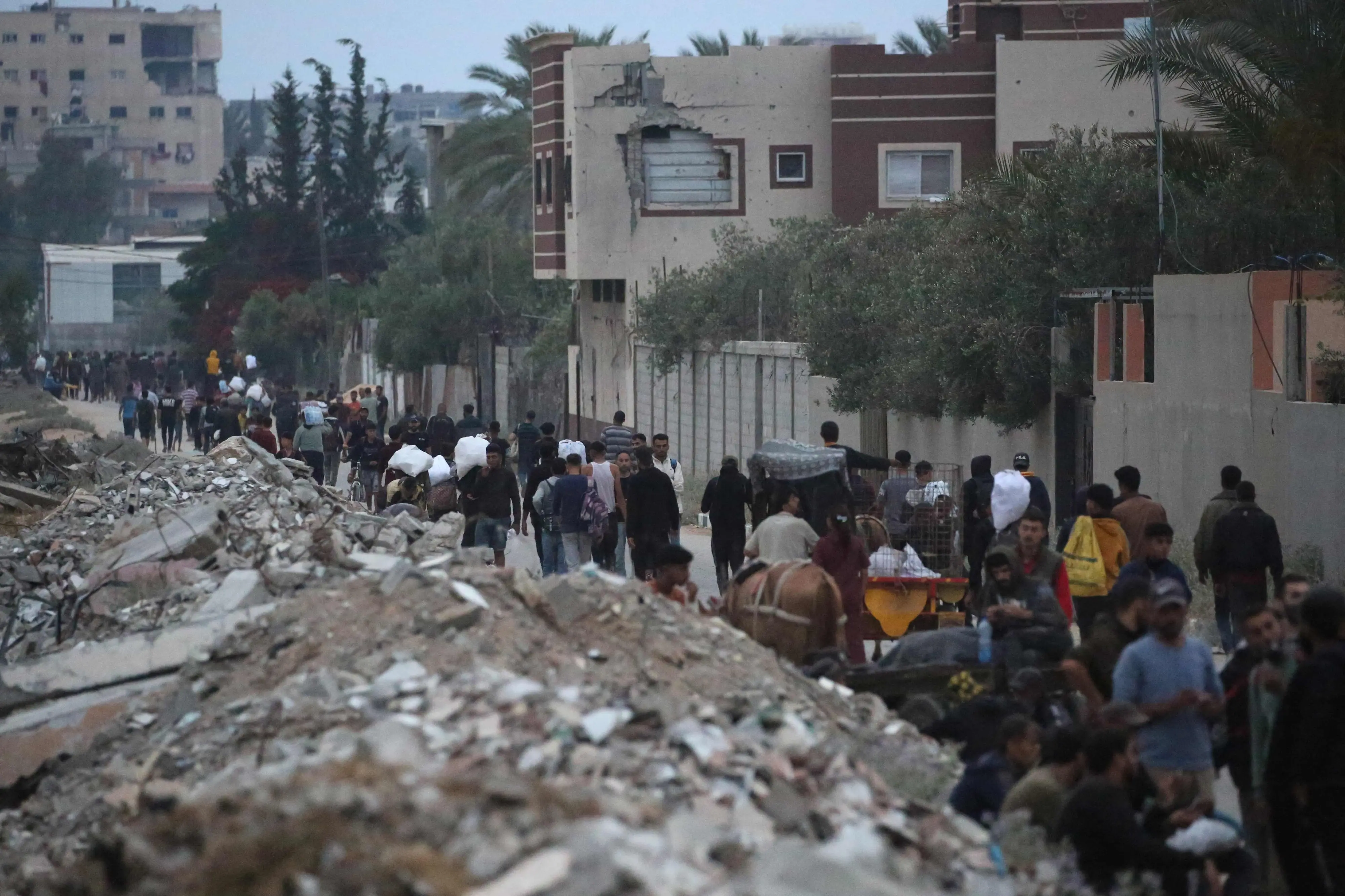Palestinians carry humanitarian aid back from a distribution point in the Bureij camp for Palestinian refugees in the central Gaza Strip. | Photo: AFP