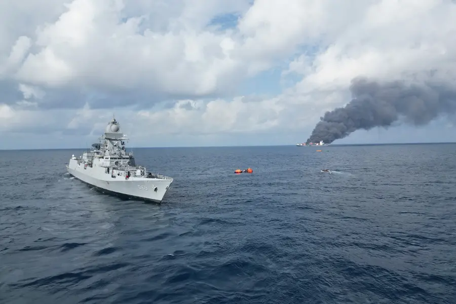 A handout photo shows an Indian Naval ship positioned near the cargo vessel that caught fire off the Kerala coast.